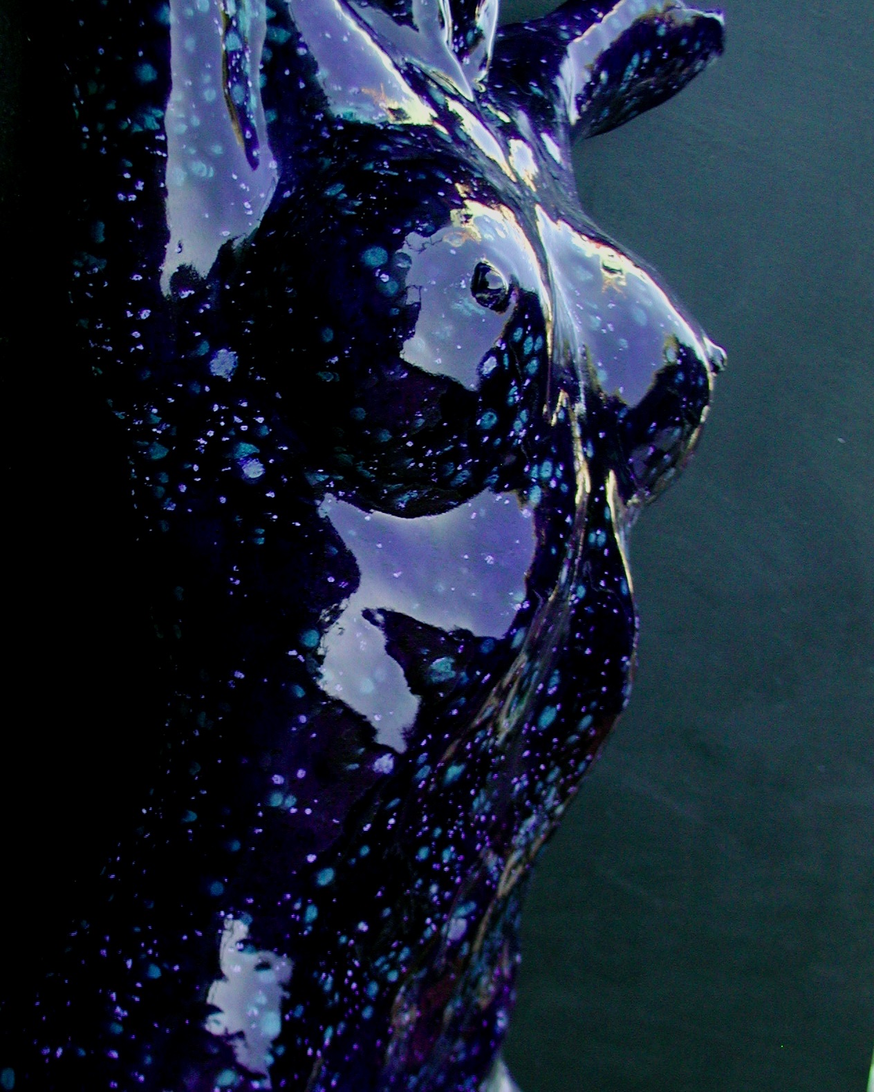 Fine-art nude in deep blue-black speckled with turquoise and violet like a starfield across the skin